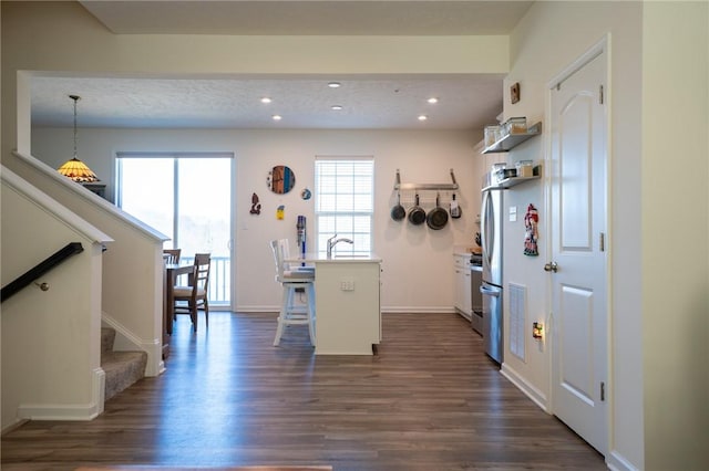 kitchen with dark wood-style floors, a breakfast bar, recessed lighting, and open shelves