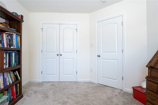 carpeted bedroom featuring baseboards and a closet