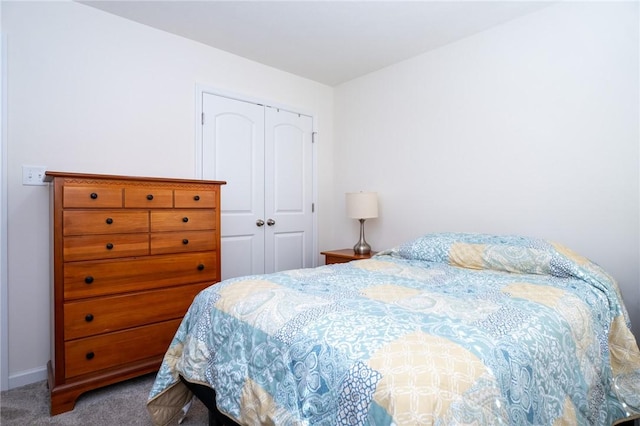 bedroom featuring a closet, baseboards, and carpet flooring