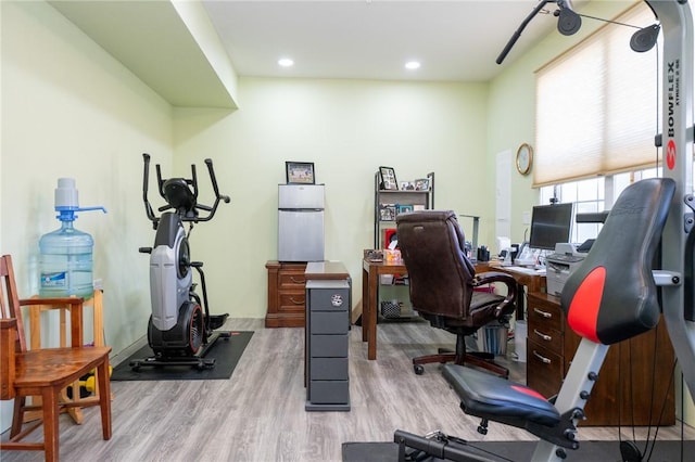 exercise area featuring wood finished floors and recessed lighting