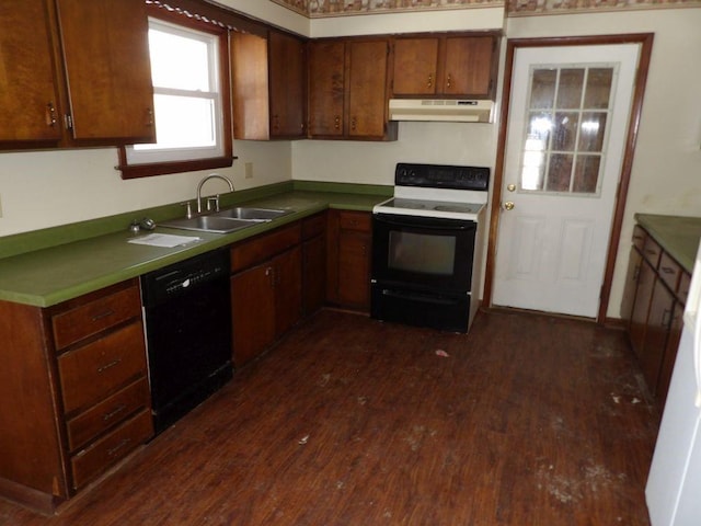 kitchen featuring black dishwasher, dark wood-type flooring, under cabinet range hood, a sink, and range with electric stovetop