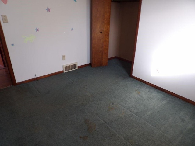 spare room featuring carpet flooring, visible vents, and baseboards