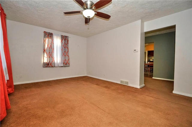 carpeted spare room featuring a textured ceiling, a ceiling fan, visible vents, and baseboards