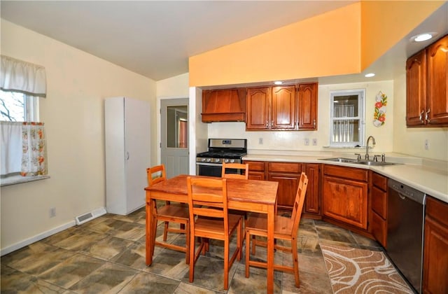 kitchen with lofted ceiling, custom range hood, visible vents, appliances with stainless steel finishes, and a sink