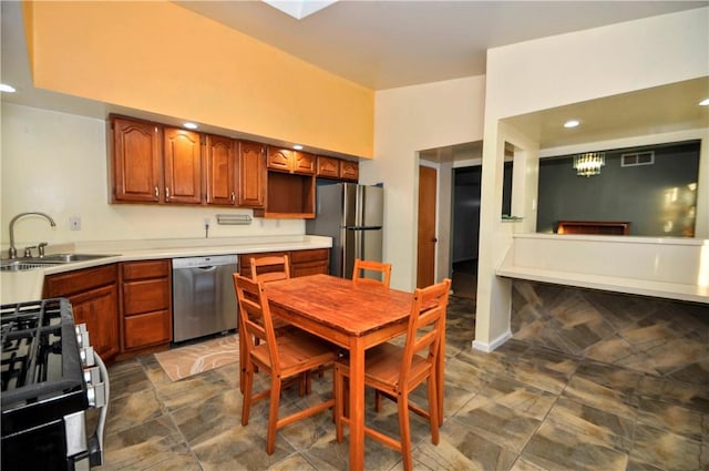 kitchen with light countertops, visible vents, appliances with stainless steel finishes, brown cabinetry, and a sink