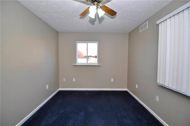 carpeted spare room featuring a textured ceiling, a ceiling fan, visible vents, and baseboards