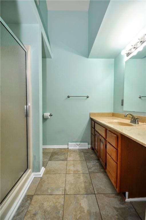 full bathroom featuring tile patterned flooring, vanity, baseboards, and a shower with shower door