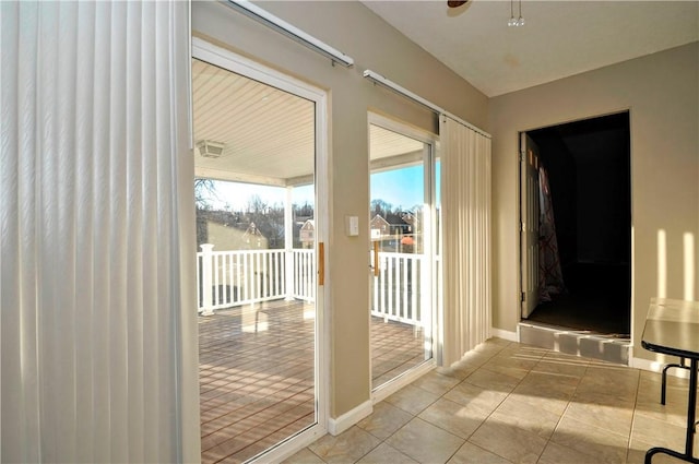 doorway to outside featuring light tile patterned floors and baseboards