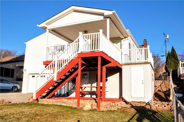 exterior space with stairs, a lawn, and a wooden deck