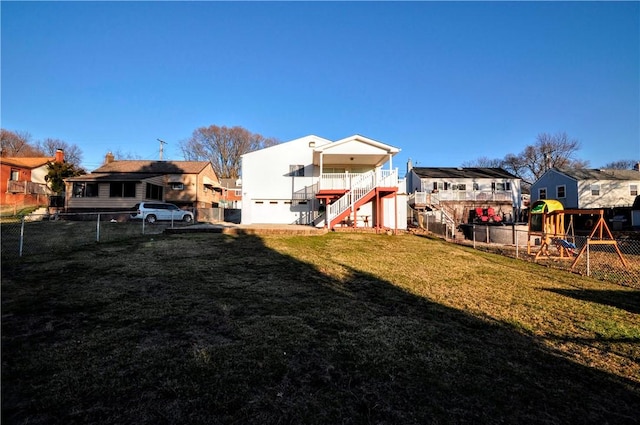 view of yard with stairs, a playground, fence, and a residential view