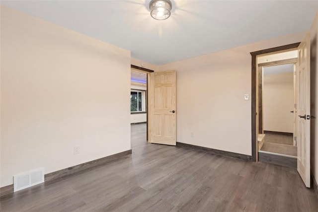 empty room with visible vents, baseboards, and wood finished floors