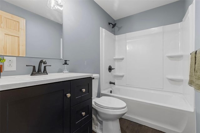 full bath featuring shower / bath combination, toilet, vanity, and wood finished floors