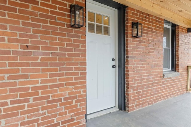 view of exterior entry featuring brick siding