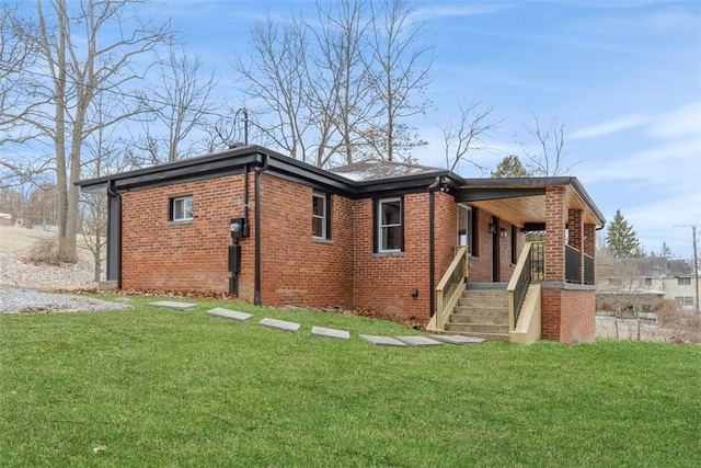 view of property exterior featuring brick siding, covered porch, and a yard