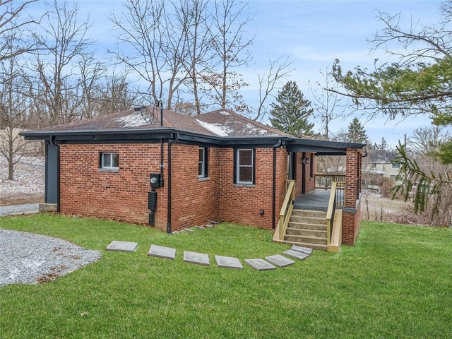 view of property exterior with brick siding, a lawn, and roof with shingles