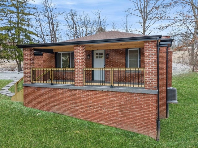 view of front of property with brick siding, a porch, and a front lawn