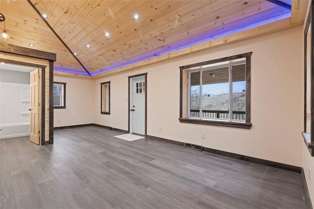 empty room featuring visible vents, baseboards, wood ceiling, lofted ceiling, and wood finished floors