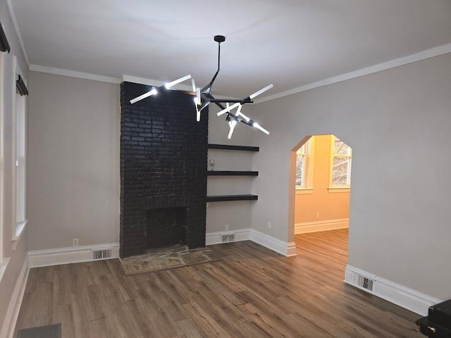 unfurnished living room featuring arched walkways, visible vents, and crown molding