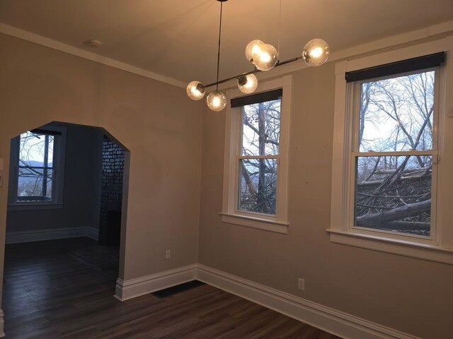 unfurnished dining area with visible vents, baseboards, dark wood finished floors, and ornamental molding