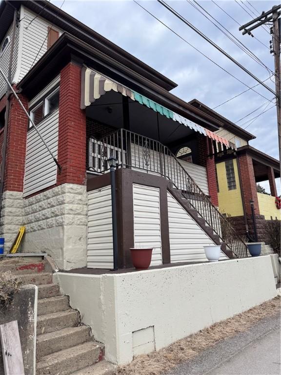 exterior space featuring stairs and brick siding