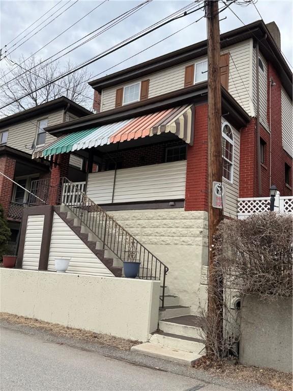 view of front of home with metal roof and stairway