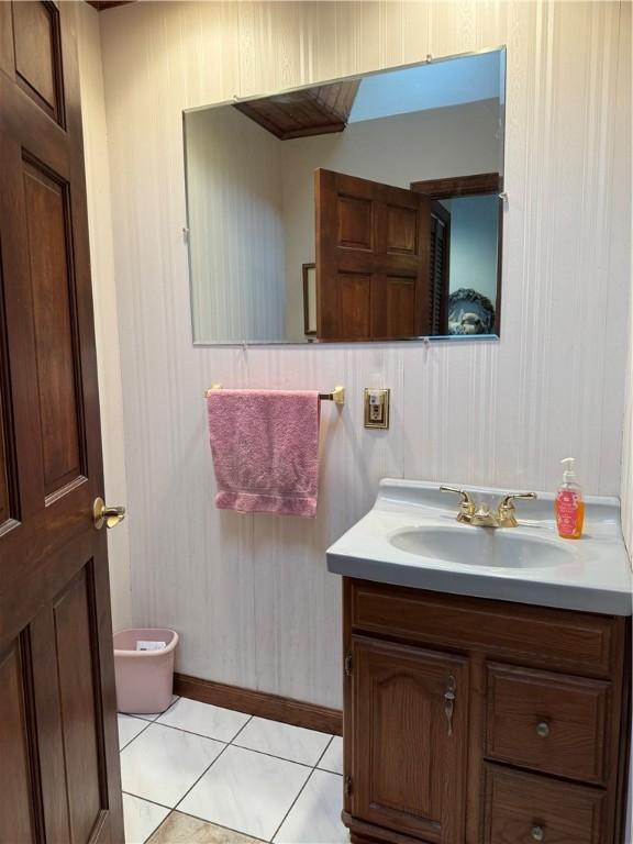 half bathroom featuring toilet, vanity, and tile patterned floors