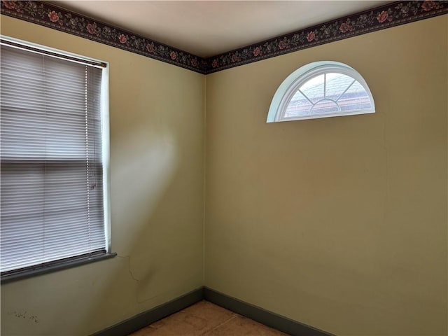 spare room with baseboards