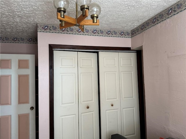 interior space featuring a textured ceiling and a textured wall