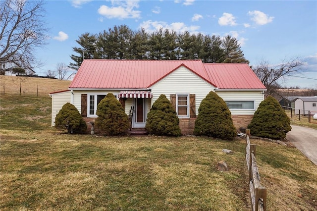 view of front of home featuring stone siding, metal roof, and a front lawn