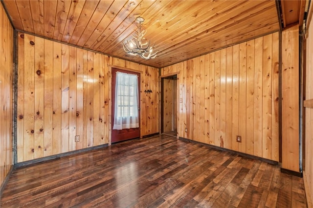 unfurnished room with an inviting chandelier, wood ceiling, and dark wood finished floors