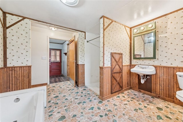 full bathroom with a stall shower, visible vents, toilet, a wainscoted wall, and wood walls