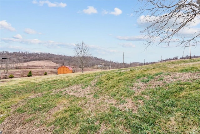 view of yard with a rural view, an outdoor structure, and a storage unit