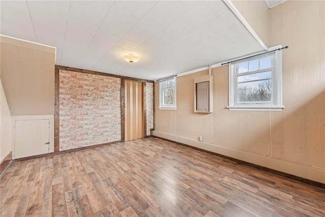 empty room with brick wall and wood finished floors