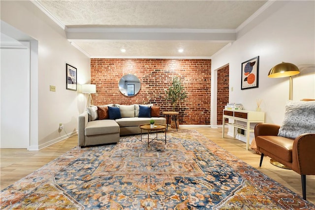 living area featuring light wood finished floors, crown molding, brick wall, and a textured ceiling