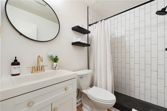 full bath featuring tiled shower, a textured ceiling, toilet, and vanity