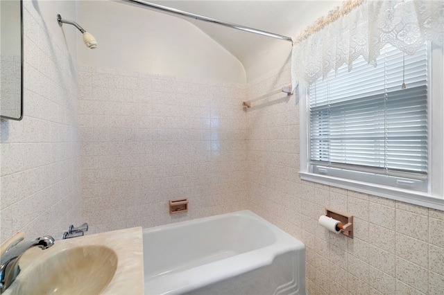 full bathroom with a sink, tile walls, and bathing tub / shower combination