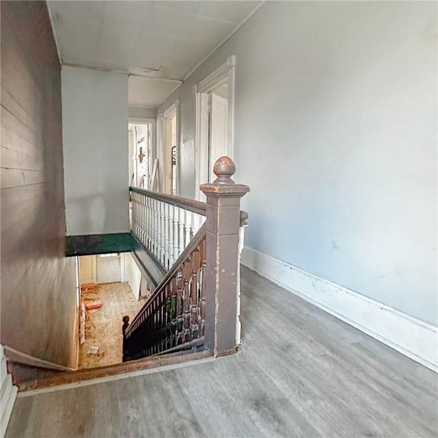 staircase featuring baseboards and wood finished floors