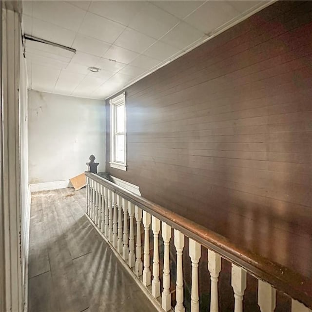 hall featuring wood finished floors and an upstairs landing