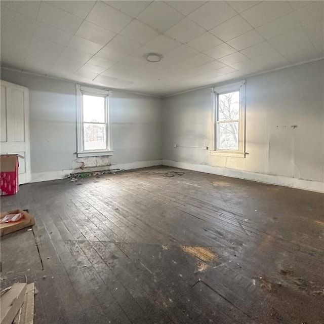 unfurnished room with hardwood / wood-style floors and baseboards