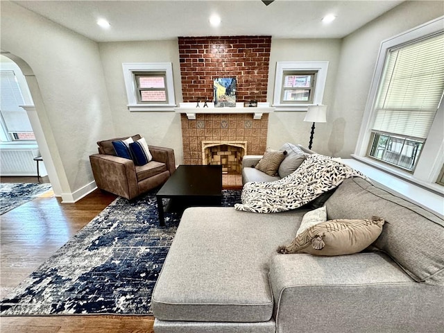 5620 Stanton Ave, East Liberty, PA 15206 - living room with arched walkways, recessed lighting, wood finished floors, baseboards, and a brick fireplace