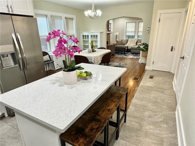 5620 Stanton Ave, East Liberty, PA 15206 - kitchen featuring visible vents, arched walkways, stainless steel refrigerator with ice dispenser, and a breakfast bar area