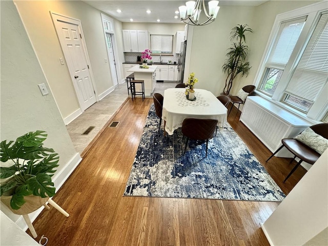 5620 Stanton Ave, East Liberty, PA 15206 - dining room featuring an inviting chandelier, light wood-style flooring, visible vents, and baseboards