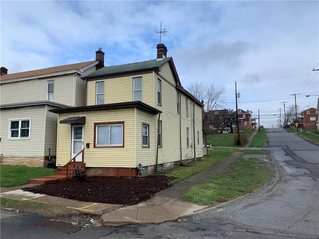 exterior space featuring entry steps and a chimney