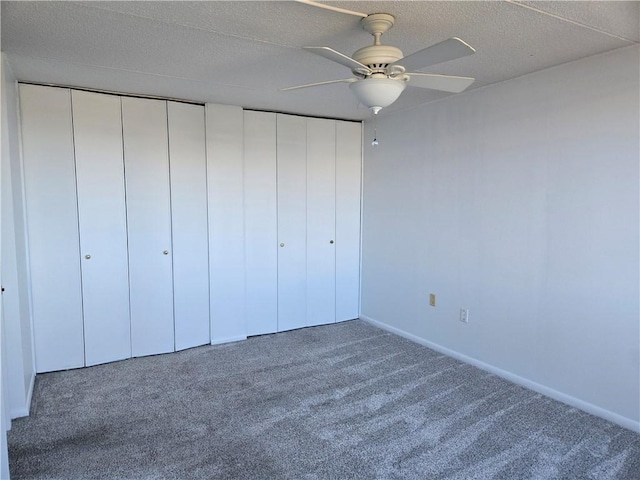 unfurnished bedroom with baseboards, a textured ceiling, ceiling fan, and carpet floors