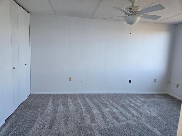 interior space with baseboards, a paneled ceiling, and ceiling fan