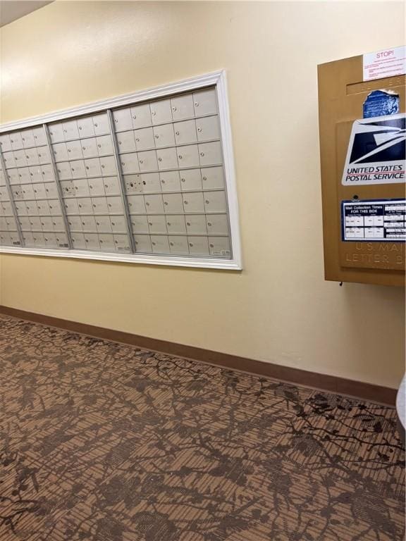 interior details featuring mail area, baseboards, and carpet flooring