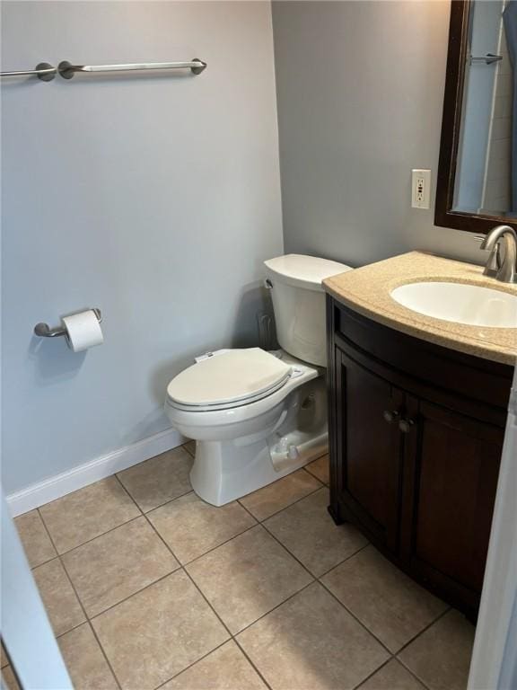 bathroom featuring tile patterned flooring, toilet, vanity, and baseboards