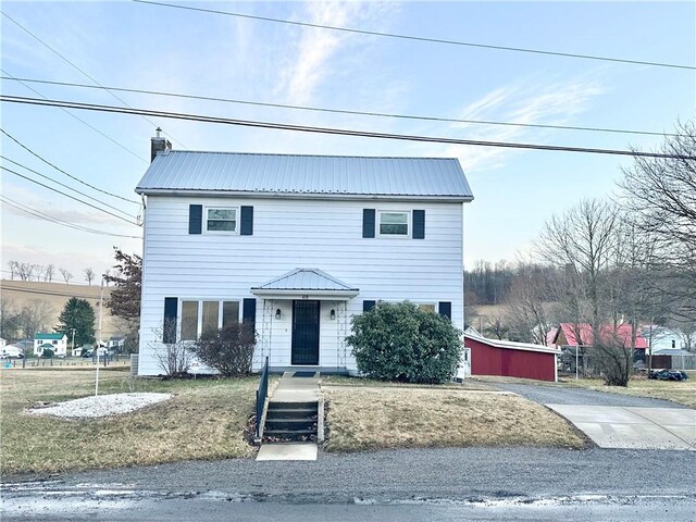 view of front of house featuring metal roof and a chimney