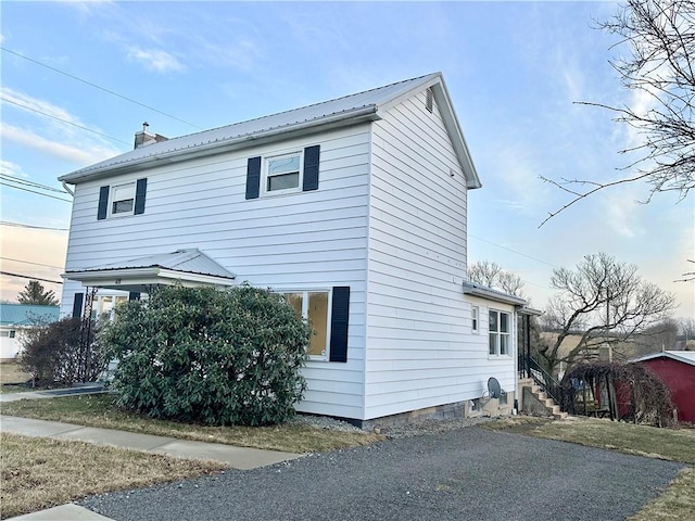 view of home's exterior with metal roof and a chimney