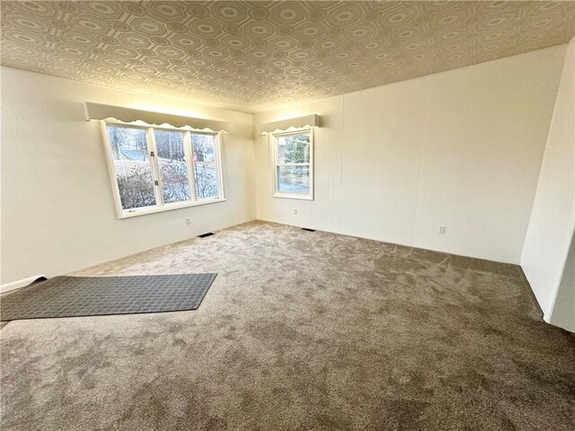 unfurnished room with an ornate ceiling, carpet flooring, and visible vents